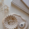 jewelry scalloped tray presenting together with aesthetic books and dried flower on the table