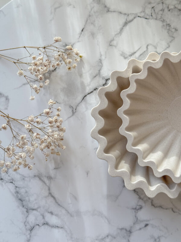 ruffled edge dish in two different sizes presenting on marble table