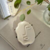 Abstract Face Tray lying on a book